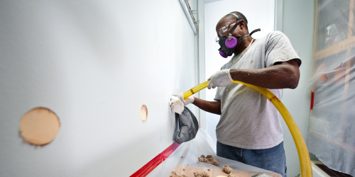 man installing wall insulation